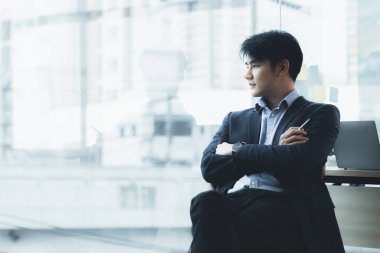 Asian man with suit, young businessman as startup company CEO, executive room, young startup company executives, run by young leaders. Management concept of startup companies and business men.