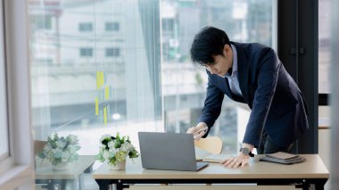 Şirketinde çalışan Asyalı bir adam, Asyalı bir işadamı özel ofiste dizüstü bilgisayarı kontrol ediyor, yönetici odası, genç şirket yöneticileri. Girişim şirketinin yönetim kavramı.