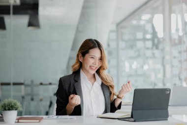 Kadın jest yapıyor ve tablet ekranına bakıyor, iş kadını aylık satışları kontrol ediyor ve satışlar planlanan hedefleri karşılarken mutluymuş gibi davranıyor. Satış yönetimi kavramı.