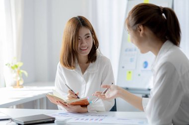 Beyaz kağıtları inceleyen ve konuşan iki kadın, beyin fırtınası ve planlama yapan iki iş kadını, bir şirket kurmak için ortaklık kuruyorlar. Girişim şirketinin yönetimi.