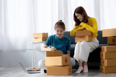 Web sitesindeki bir internet mağazasının iki sahibi, internet sitesinden gelen siparişler doğrultusunda müşterilere gönderilecek paketler hazırlıyor, bilgileri kontrol ediyor ve müşterilere teslimat için hazırlanıyorlar..