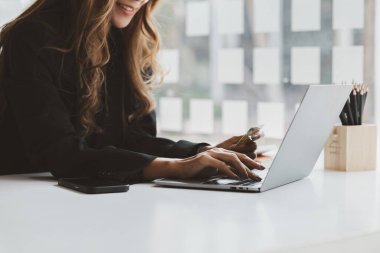 Kredi kartı tutan güzel bir kadın, internet üzerinden mal ve hizmetleri ödemek için kredi kartı kullanıyor, online alışveriş için kredi kartı kullanma kavramı, internet sitesinden mal ve hizmet sipariş etme kavramı.