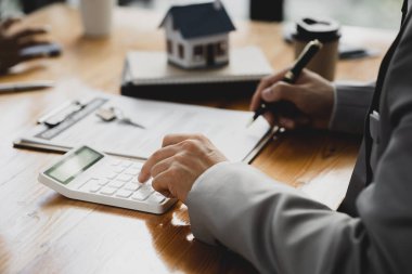 Kiralama şirketi çalışanı, müşteri kira sözleşmesini imzalamadan önce kira sözleşmesinin detaylarını ve şartlarını açıklamadan önce detayları tartışıyor. Emlak kiralama fikirleri.