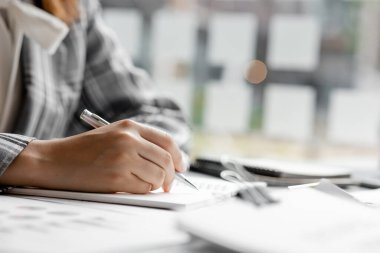 İşadamı bir deftere not alır, bir şirket kurar, ofisinde oturur ve finans departmanı tarafından hazırlanan mali özeti kontrol eder. Girişim şirketinin yönetim kavramı.