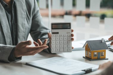 Real estate agents explain models of housing estates in projects to elaborate to clients, explaining and presenting information about homes and purchasing loans. Real estate trading concept.