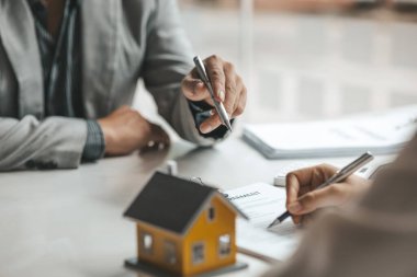 A rental company employee is calculating the cost for the customer to agree to sign a rental contract, explaining the rental terms and conditions. Home and real estate rental ideas.