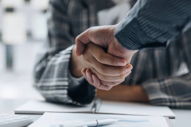 Close-up two business men holding hands, Two businessmen are agreeing on business together and shaking hands after a successful negotiation. Handshaking is a Western greeting or congratulation.