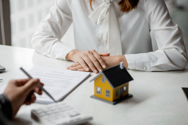 Real estate agents explain models of housing estates in projects to elaborate to clients, explaining and presenting information about homes and purchasing loans. Real estate trading concept.