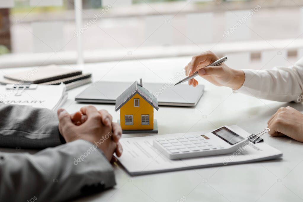 Real estate agents explain models of housing estates in projects to elaborate to clients, explaining and presenting information about homes and purchasing loans. Real estate trading concept.