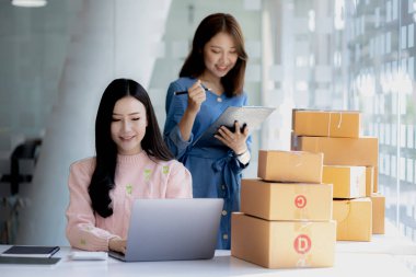 Web sitesindeki bir internet mağazasının iki sahibi, internet sitesinden gelen siparişler doğrultusunda müşterilere gönderilecek paketler hazırlıyor, bilgileri kontrol ediyor ve müşterilere teslimat için hazırlanıyorlar..