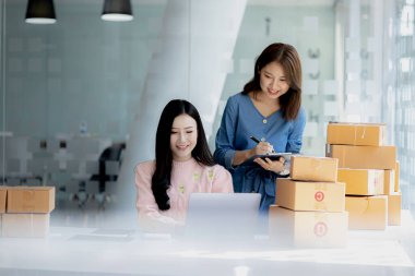 Web sitesindeki bir internet mağazasının iki sahibi, internet sitesinden gelen siparişler doğrultusunda müşterilere gönderilecek paketler hazırlıyor, bilgileri kontrol ediyor ve müşterilere teslimat için hazırlanıyorlar..