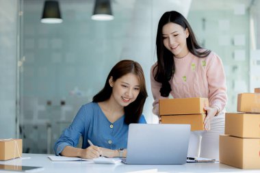 Web sitesindeki bir internet mağazasının iki sahibi, internet sitesinden gelen siparişler doğrultusunda müşterilere gönderilecek paketler hazırlıyor, bilgileri kontrol ediyor ve müşterilere teslimat için hazırlanıyorlar..