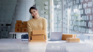 Online mağaza platformunda ürün satan bir şirketin kadın sahibi, bir kurye şirketi aracılığıyla mal gönderen, iş planlayan. Çevrimiçi satış ve online alışveriş kavramları.