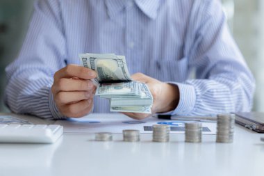 Individuals are counting dollars, ways to save money for future investments and spending, money growth, stock investments. The idea of investing money to make it worthwhile to grow and be sustainable.