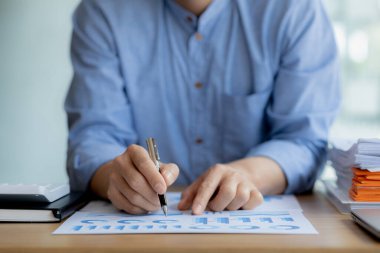 Şirket mali bilgilerini gösteren bir tabloya işaret eden işadamı, şirketin mali bilgilerini harita halinde gösteren özel bir ofiste oturuyor. Finansal kavramlar