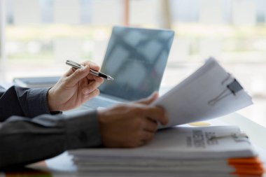 Şirket mali bilgilerini gösteren bir tabloya işaret eden işadamı, şirketin mali bilgilerini harita halinde gösteren özel bir ofiste oturuyor. Finansal kavramlar