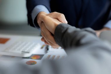 Yakın plan iki iş adamı el ele tutuşuyor, iki işadamı iş konusunda hemfikir ve başarılı bir pazarlıktan sonra el sıkışıyor. El sıkışmak Batının selamlaması ya da kutlamasıdır..