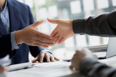 Close-up two business men holding hands, Two businessmen are agreeing on business together and shaking hands after a successful negotiation. Handshaking is a Western greeting or congratulation.