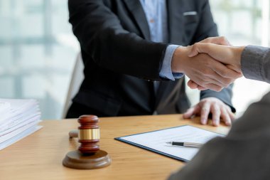 Lawyers shake hands with clients who come to testify in the case of embezzlement from business partners who jointly invest in the business. The concept of hiring a lawyer for legal proceedings.