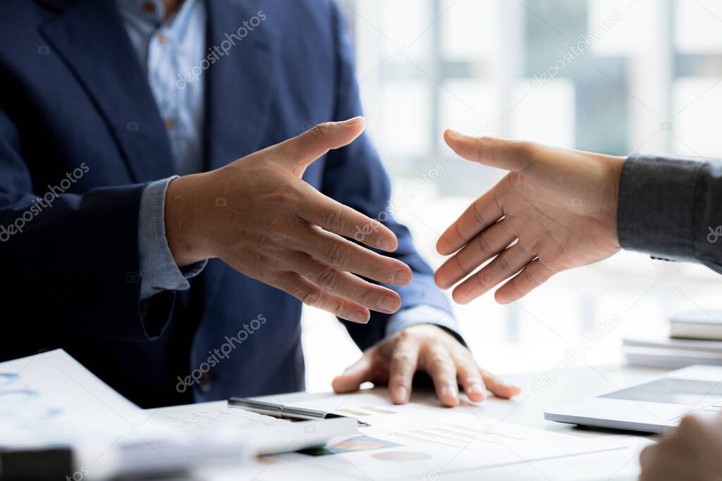 Close-up two business men holding hands, Two businessmen are agreeing on business together and shaking hands after a successful negotiation. Handshaking is a Western greeting or congratulation.