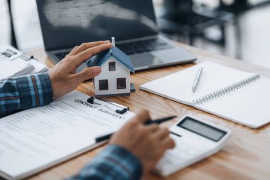 Real estate agents explain models of housing estates in projects to elaborate to clients, explaining and presenting information about homes and purchasing loans. Real estate trading concept.