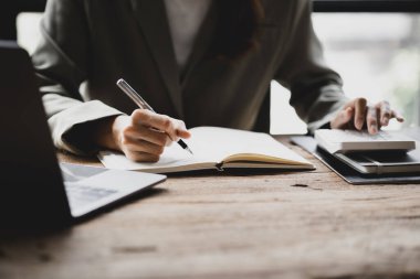 İşadamı bir deftere not alır, bir şirket kurar, ofisinde oturur ve finans departmanı tarafından hazırlanan mali özeti kontrol eder. Girişim şirketinin yönetim kavramı.