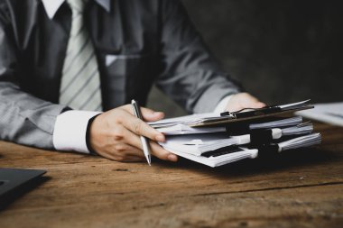 Şirketin mali belgelerini elinde tutan bir işadamı, finans departmanıyla bir toplantıya katılmadan önce şirketin mali durumunu kontrol ediyor. Kurumsal mali yönetim kavramı.