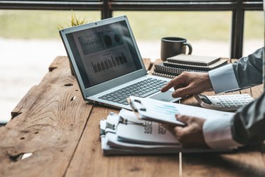 Özel bir odada çalışan yakın plan bir iş adamı, dizüstü bilgisayarda klavye kullanıyor, ortağıyla sohbet etmek için bir kurye kullanıyor. İletişim için teknoloji kullanma kavramı.