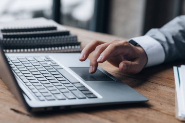 Özel bir odada çalışan yakın plan bir iş adamı, dizüstü bilgisayarda klavye kullanıyor, ortağıyla sohbet etmek için bir kurye kullanıyor. İletişim için teknoloji kullanma kavramı.