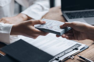 Ev ve Gayrimenkul Satış Fikirleri, iki kişi emlakçı ve ayrıntıları tartıştıktan ve bir satın alma anlaşması yaptıktan sonra bir müşteri mülkün satışı için para alıyor.