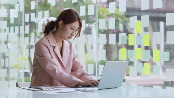 在一家公司的私人办公室里坐着一位漂亮的亚洲女人 她是一位经营一家公司的女商人 她正计划发展一家公司 企业管理概念 — 图库视频影像