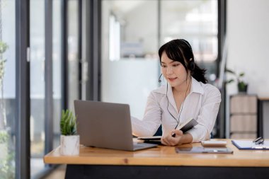 Güzel bir Asyalı kadın, bir internet ve telefon şirketinde çağrı merkezi çalışanı, telefon aracılığıyla müşterilere hizmet ve yardım sağlamaktan sorumludur. Çağrı merkezi kavramı.