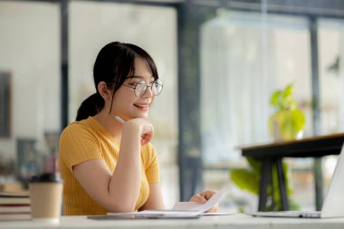 Sınıfta öğretmen ve arkadaşa iş sunan güzel Asyalı kadın, İnternet 'te okuyor. Sınıfta bir salgını önlemek için COVID-19 salgını nedeniyle çevrimiçi öğrenme kavramı.