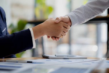 Yakın plan iki iş adamı el ele tutuşuyor, iki işadamı iş konusunda hemfikir ve başarılı bir pazarlıktan sonra el sıkışıyor. El sıkışmak Batının selamlaması ya da kutlamasıdır..