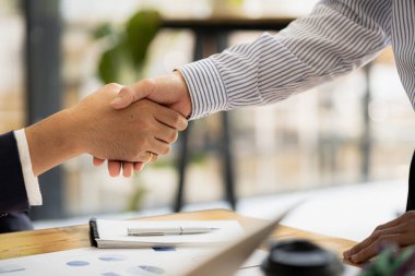 Close-up two business men holding hands, Two businessmen are agreeing on business together and shaking hands after a successful negotiation. Handshaking is a Western greeting or congratulation.