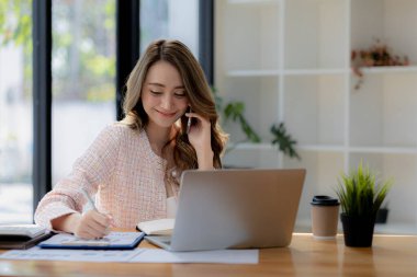 Telefonda konuşan Asyalı bir kadın, bir girişim şirketinde satış elemanı, ürün ve promosyon satmak için müşterileri arıyor. Telefon kanalları aracılığıyla ürün satma kavramı.