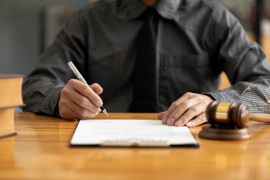 Avukatlar, müvekkilin dolandırıcılık yapan bir şirkette çalışan bir çalışana dava açtığı sözleşme belgelerini gözden geçiriyorlar. Avukat ve hukukun düzgün ve adil kullanımı.