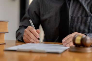 Avukatlar, müvekkilin dolandırıcılık yapan bir şirkette çalışan bir çalışana dava açtığı sözleşme belgelerini gözden geçiriyorlar. Avukat ve hukukun düzgün ve adil kullanımı.