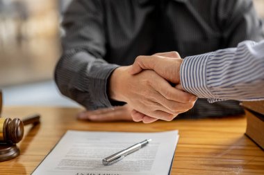 Lawyers shake hands with clients who come to testify in the case of embezzlement from business partners who jointly invest in the business. The concept of hiring a lawyer for legal proceedings.