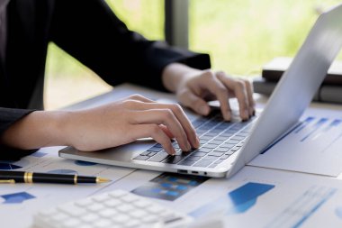 Bir iş adamı şirketin mali belgelerini kontrol ediyor ve bir mesajlaşma programı aracılığıyla finans müdürüyle konuşmak için dizüstü bilgisayar kullanıyor. Şirket mali yönetimi kavramı.