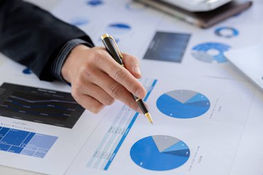 A business finance woman is reviewing a company's financial documents prepared by the Finance Department for a meeting with business partners. Concept of validating the accuracy of financial numbers.