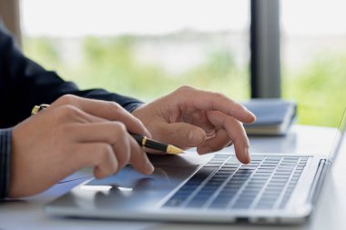 A business man is checking company financial documents and using a laptop to talk to the chief financial officer through a messaging program. Concept of company financial management.