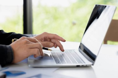 Bir iş adamı şirketin mali belgelerini kontrol ediyor ve bir mesajlaşma programı aracılığıyla finans müdürüyle konuşmak için dizüstü bilgisayar kullanıyor. Şirket mali yönetimi kavramı.