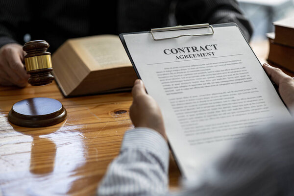 The individual is reading the attorney's contract after consulting and providing detailed information about the case. Lawyer concept and the use of law properly and fairly.