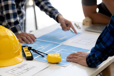 Mimarlar ve inşaat mühendisleri beyin fırtınası fikirleri, mimar mühendisleri ev ve iç yapılar tasarlıyor ve bir tasarım programı aracılığıyla planlar çiziyorlar. Bina tasarımının mimarı.
