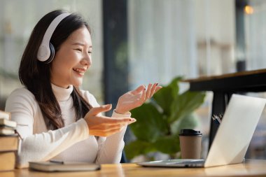 Sınıfta öğretmen ve arkadaşa iş sunan güzel Asyalı kadın, İnternet 'te okuyor. Sınıfta bir salgını önlemek için COVID-19 salgını nedeniyle çevrimiçi öğrenme kavramı.