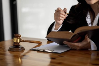 Bir kadın oturur ve hukuk kitabı okur, müvekkillerine davalar için hizmet veren bir avukattır, çeşitli davalarda tavsiye verir ve kavga eder. Bu tam olarak onaylandı. Avukat kavramı ve adalet.