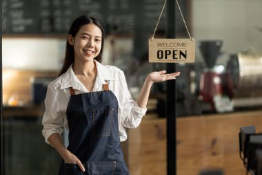 Mağazadaki kadın resepsiyonist. Dükkanı aç / kapat tabelasıyla, bir kafede çalışıyor ve dükkâna hizmet veren müşterilere hizmet veriyor. Bir kafeye hizmet etme kavramı.