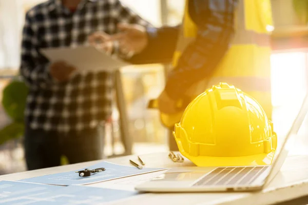 Helmets are used for construction work to ensure safety at work, Architect engineers design houses and interior structures and draw plans through design programs. Architect concept of building design.