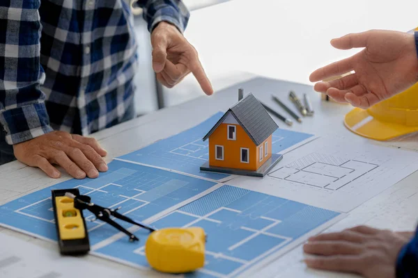 Architects design team is looking at models of small houses, Architect engineers design houses and interiors and draw floor plans through design program. Architect concept of building design.